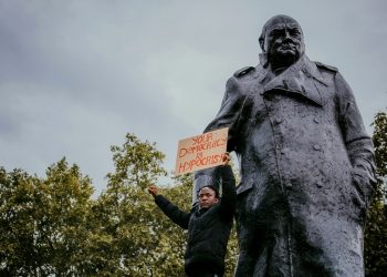 Protestor by statue of Churchill