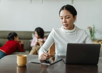 woman working while children play
