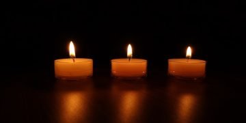 Lit tea lights, shining a light on male violence against women.