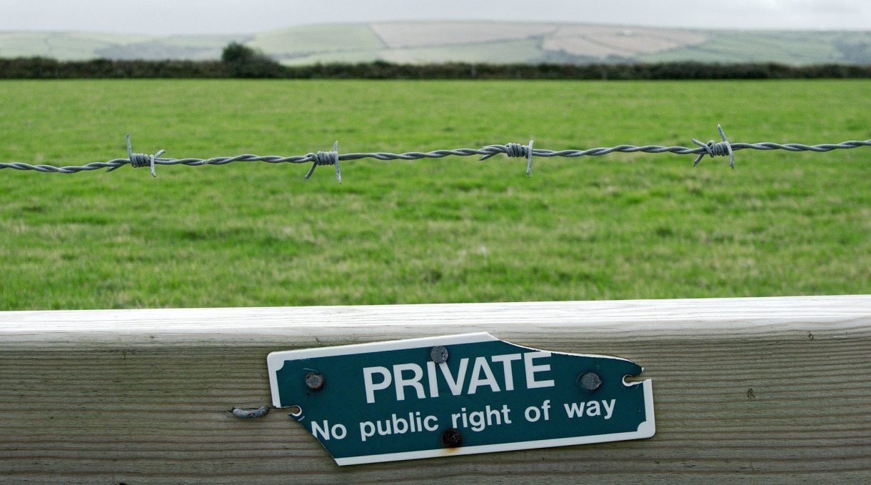 Private property sign on a barbed wire fence in the UK countryside