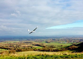 A glider flies over the South Downs near Ditchling Beacon, East Sussex