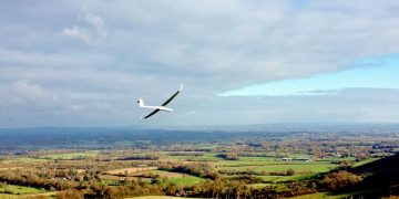 A glider flies over the South Downs near Ditchling Beacon, East Sussex