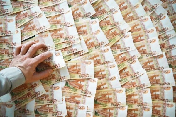 Photo showing a hand touching a huge pile of bank notes