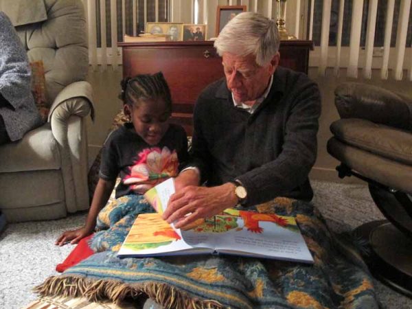 Image of man reading with young child