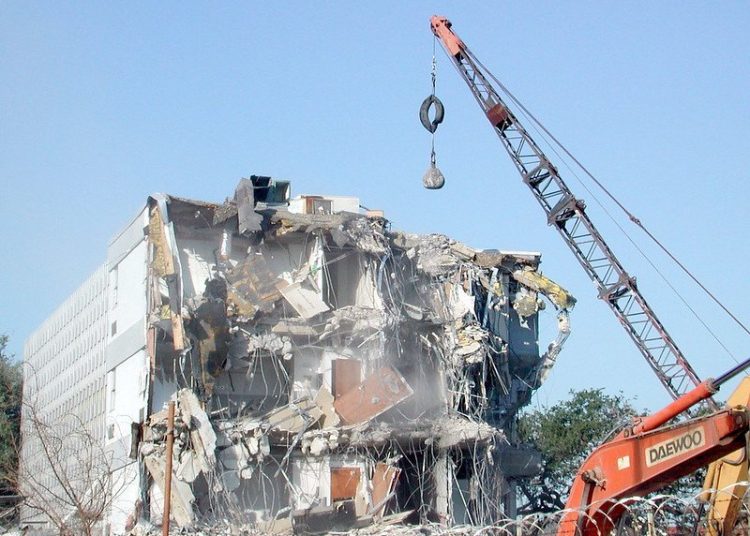 Photo of a wrecking ball and a half-demolished building.