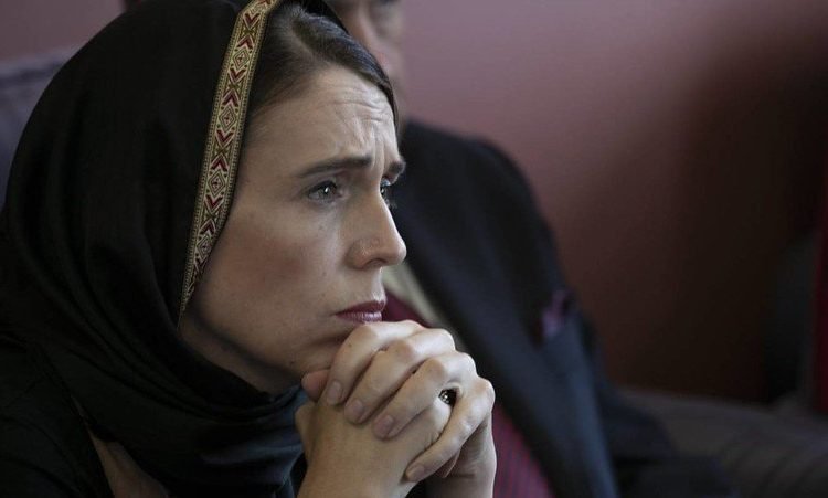 Jacinda Ardern looking throughtful wearing a headscarf