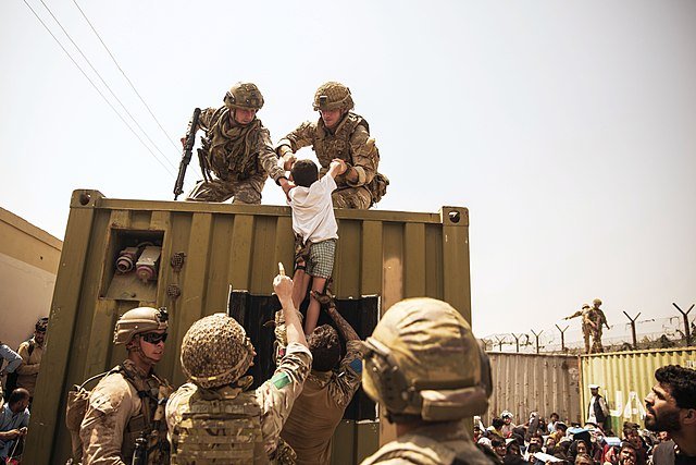 Operation Pitting. UK coalition forces assist an Afghan child during the evacuation at Hamid Karzai international airport, Kabul, Afghanistan, 20 August 2021.