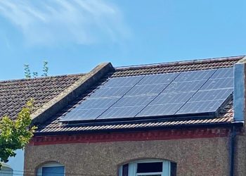 Solar panels cover a terraced house with a pebble-dashed front