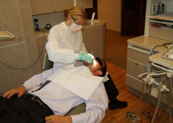 A dentist treats a patient in a dental surgery