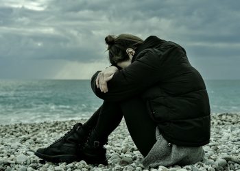 Unsettled, downhearted woman on beach