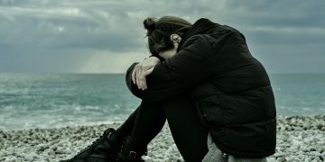 Unsettled, downhearted woman on beach