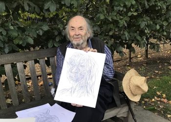 Quentin Blake sitting on a bench with some of his imaginary portraits.