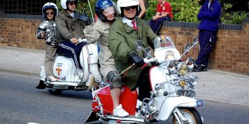 Mods on Lambretta scooters in parade.