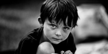 Sad little boy looking into the lens