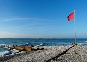Red flag at East Head: the entrance to Chichester Harbour. Photo credit, grumpylumixuser, Wikimedia Commons