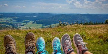 Picture of three ramblers' boots looking over the countryside.