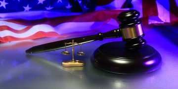 A gavel , scales and the American flag