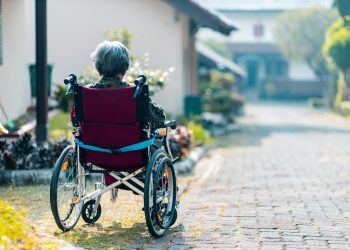 Woman sitting on wheelchair outdoors