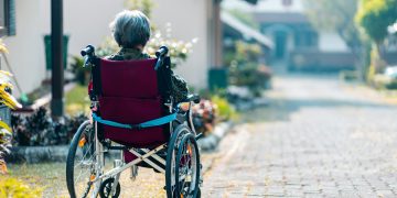 Woman sitting on wheelchair outdoors