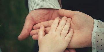 Photo of Man, Woman and child's hands linked