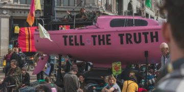 Protestors having a rally in the middle of road against global warming.