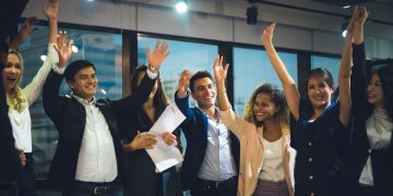 a team of people celebrating success with hands in the air