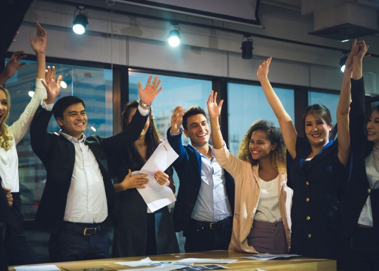 a team of people celebrating success with hands in the air