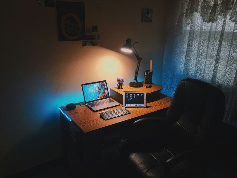 A desk with a computer and a lamp.