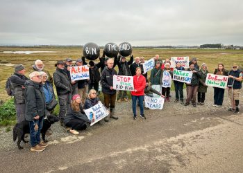 A group gathered in Sussex with protest placards.