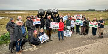 A group gathered in Sussex with protest placards.