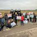 A group gathered in Sussex with protest placards.