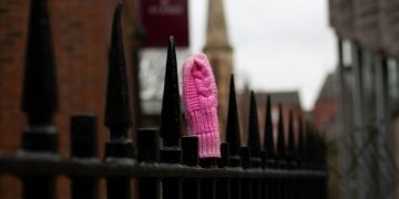 A pink glove on a railing