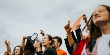 Lady with a microphone surrounded by protestors