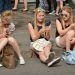 A group of girls sitting outside whilst scrolling on their phones.