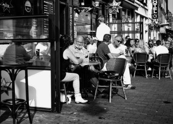 Black and white of people eating outside a cafe