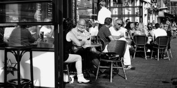 Black and white of people eating outside a cafe