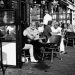 Black and white of people eating outside a cafe