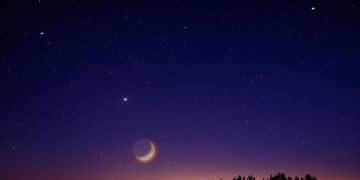 The night sky with stars and a partial moon