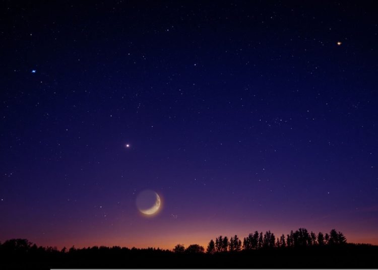 The night sky with stars and a partial moon