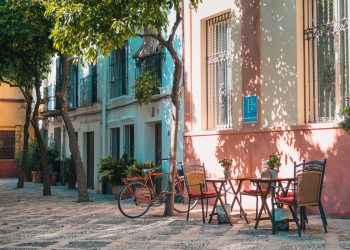 A table and chairs and a bike in a village in Spain