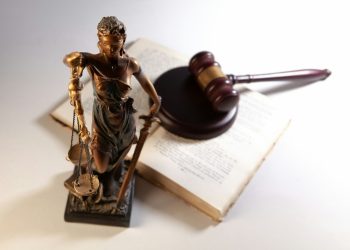 Statue of justice, gavel, and open book on table