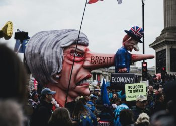 people protesting Brexit with image of Theresa May with an enormous nose with Brexit written on the side it spearing the UK