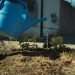 Blue watering can watering leaves