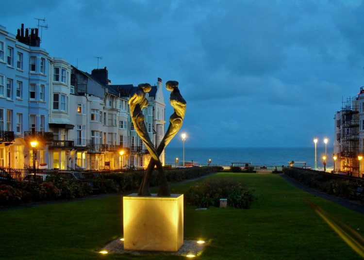 An image of Brighton's seafront, dimly lit under the night sky.