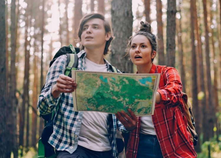 Boy and girl in a forest looking at a map