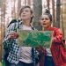 Boy and girl in a forest looking at a map