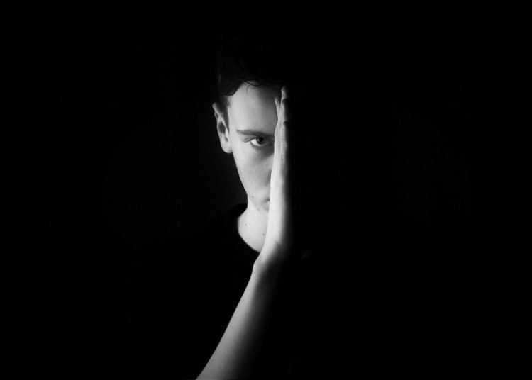 man with hand in front of half of his face