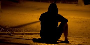 man sitting on the ground alone