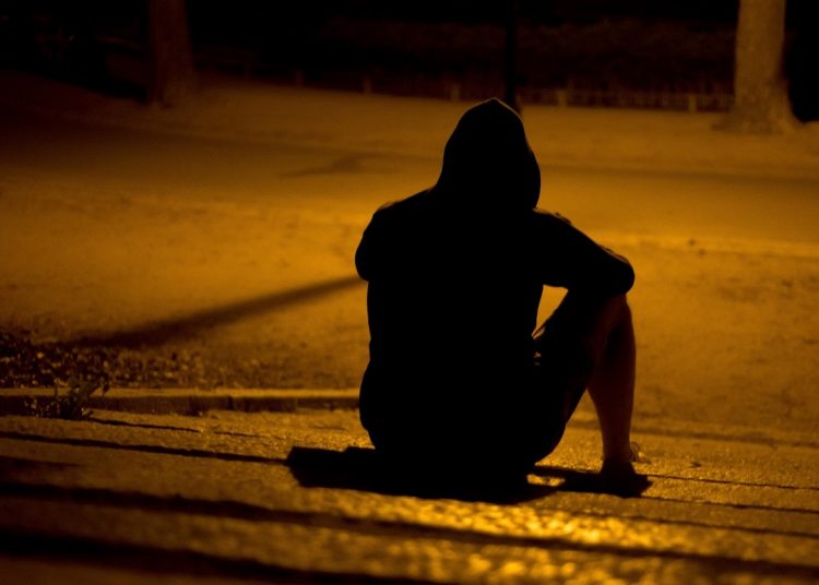man sitting on the ground alone